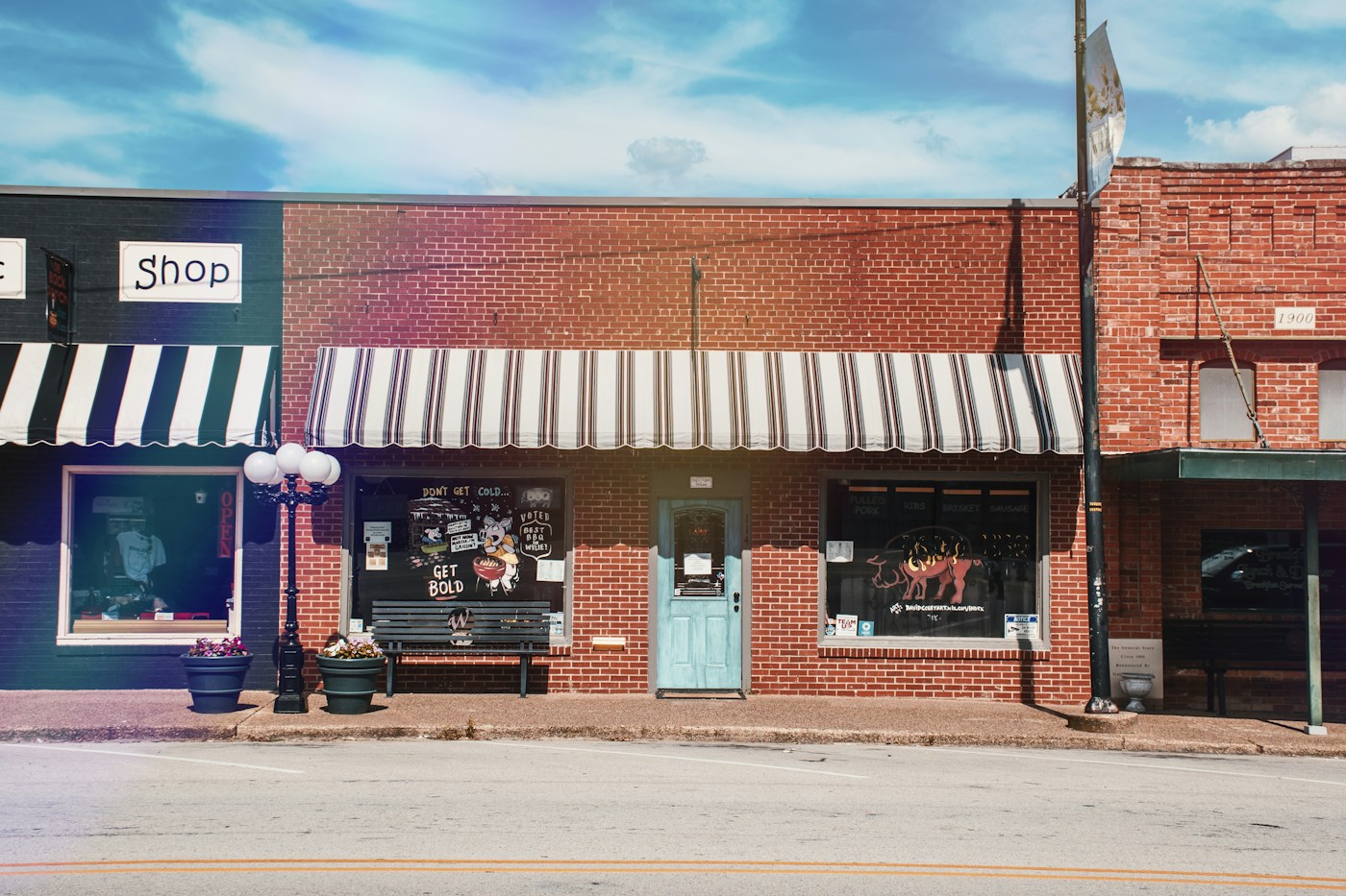 Brick retail storefront with clean windows and striped awnings — illustrative commercial property